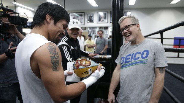 Ball of fun:  Manny Pacquiao and his trainer Freddie Roach share a laugh as they look at a speed bag showing an images of Floyd Mayweather Jr.