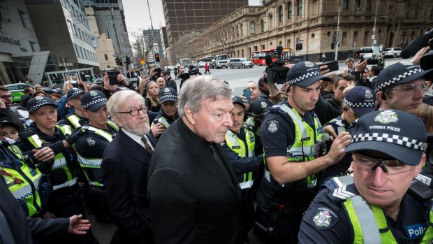 Cardinal George Pell, with his lawyer Robert Richter QC, leave court amid chaotic scenes.