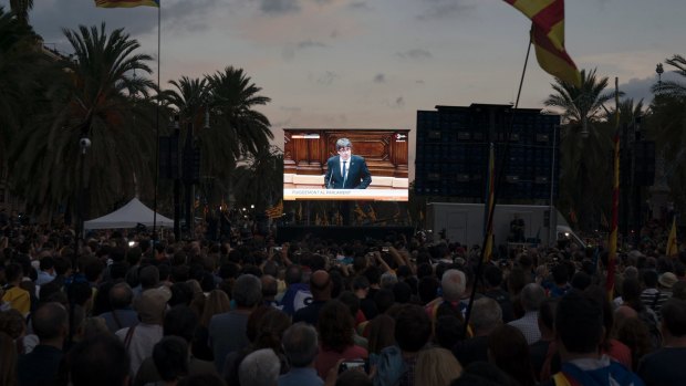 Pro-independence supporters during a rally as they watch Catalan President Carles Puigdemont speaking on a giant screen in Barcelona.