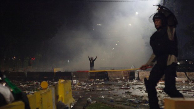 Police and a protester gesturing during the violent clashes in Jakarta. 