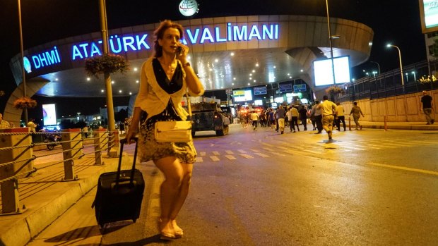 A passenger scrambles away as Turkish army tanks enter the Ataturk Airport in Istanbul.