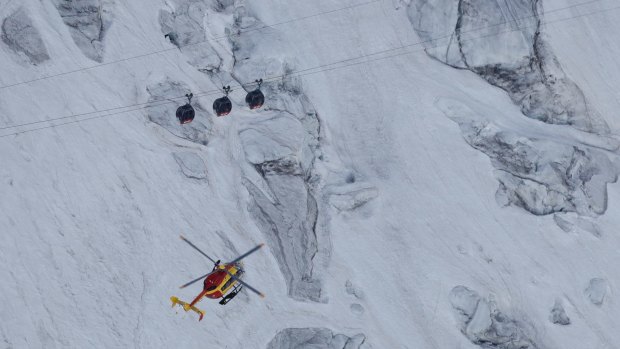 A French helicopter hovers near three cars of the Panoramic Mont Blanc cable car on Friday.