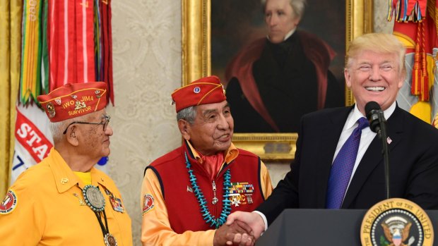 President Donald Trump, right, meets with Navajo Code Talkers Peter MacDonald, centre, and Thomas Begay, left, in the Oval Office