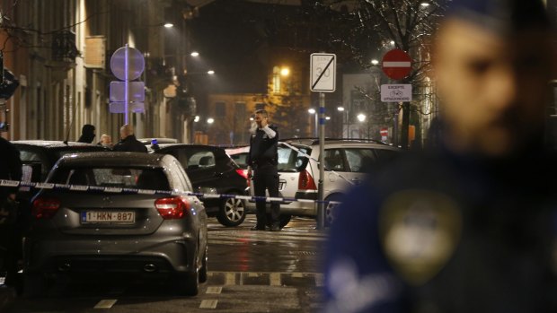 Police guard a check point during a police raid in the suburb of Schaerbeek in Brussels on Friday.