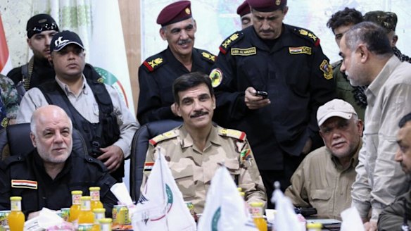 Iraqi Prime Minister Haider al-Abadi, seated in black, meets officers at the Fallujah Operation command centre on Monday. Also seated in a beige baseball cap is Hadi al-Amiri, head of the Iranian-funded Shiite militia known as the Badr Organisation.