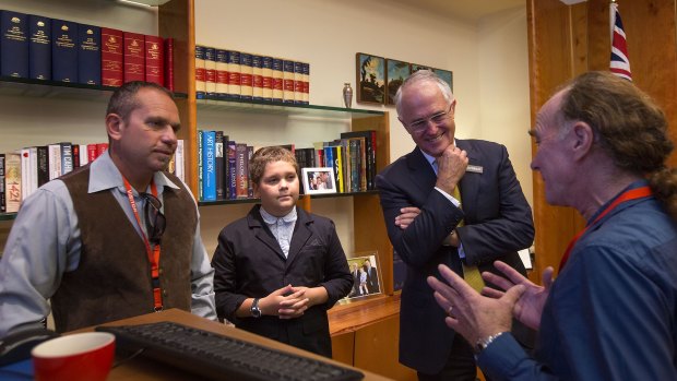 Tyronne Bell, left, with his son Jai and Glen Freeman help Malcolm Turnbull prepare to address the Parliament in the language of the Ngunawal people.