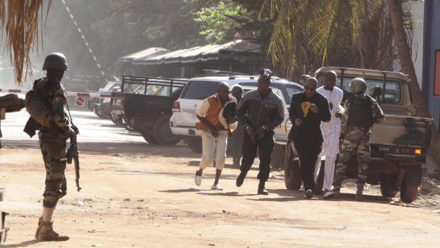 Hostages flee the Radisson Blu hotel in Mali. The man in the black suit is reportedly Guinean singer Sekouba Bambino, who escaped.
