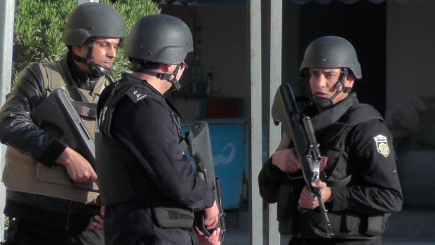 Tunisian police officers take positions during clashes with militants in Ben Guerdane.