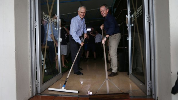 Prime Minister Malcolm Turnbull and Opposition Leader Bill Shorten help with clean-up efforts in Bowen, Queensland on Thursday.