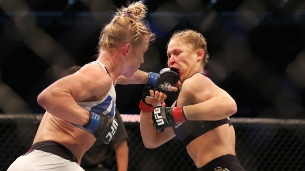 Heavy contact: Holly Holm lands a punch on Ronda Rousey.