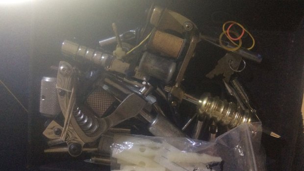 A tattoo gun found at a Gold Coast homePolice officers found tattoo guns, ink bottles and sketchbooks during a raid on an alleged backyard tattoo shop on the Gold Coast.