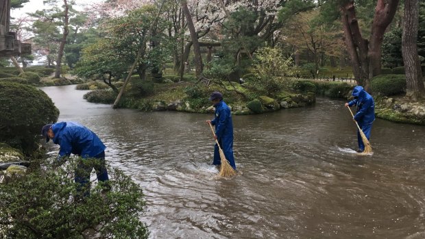 Gardeners sweep the waterways at the 17th century Kenroku-en in Kanazawa, Japan.