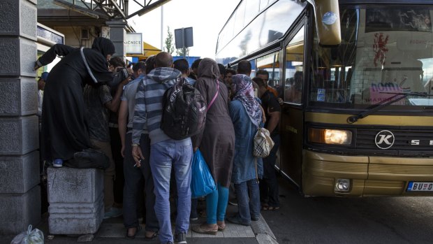 People collect their papers after getting off a bus from Proshevo at the main bus station in Belgrade, Serbia. 