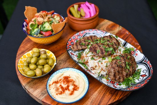 Shish kofta platter with fattoush, pickles and hummus.