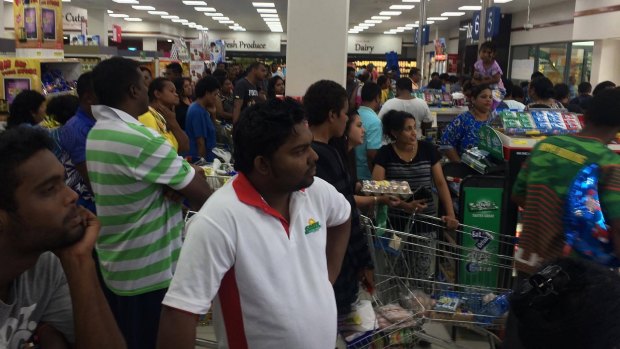 People queue in a supermarket in Suva ahead of Cyclone Winston's landfall. 
