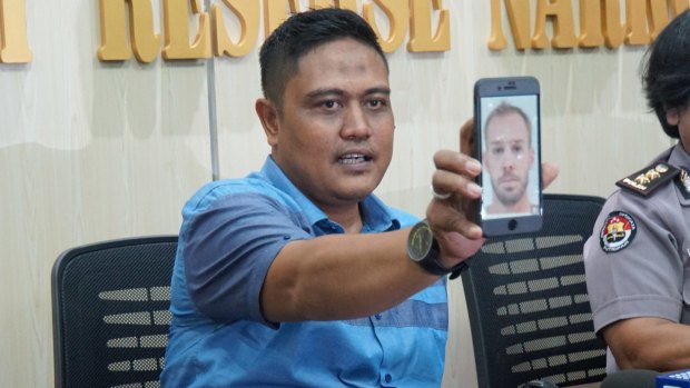 The deputy director of narcotics for Bali police, Sudjarwoko, holds a photo of Joshua James Baker at a press conference.
