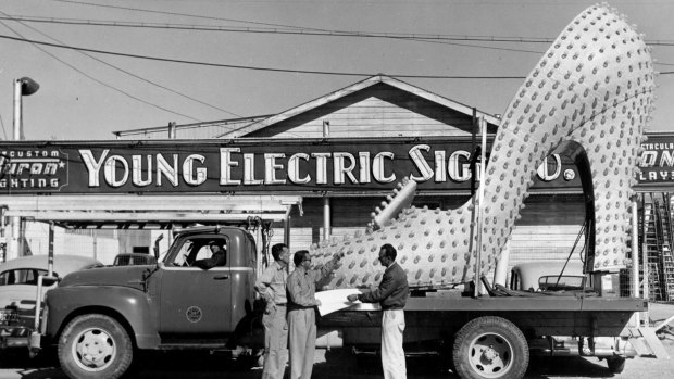 The use of neon seems almost limitless as a giant shoe is loaded for transport. 