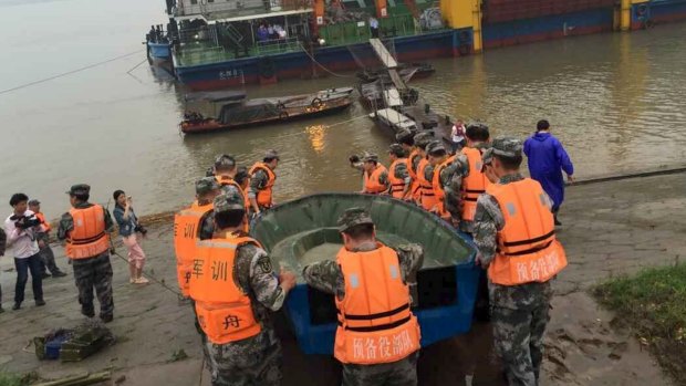 Rescue workers carry a boat to conduct a search after a ship sank at the Jianli section of Yangtze River.
