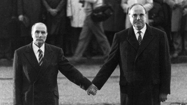 The late French President Francois Mitterrand and then German Chancellor Helmut Kohl stand hand in hand as they listen to the national anthems during a French-German reconciliation ceremony near Verdun in 1984. The 10-month Battle of Verdun saw 163,000 French and 143,000 German soldiers killed.