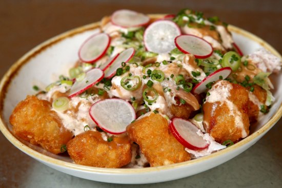 Tater tots topped with blue cheese dressing, radish and smoked chicken.
