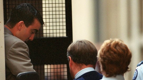 Convicted police killer Jason Roberts is led into court by security.