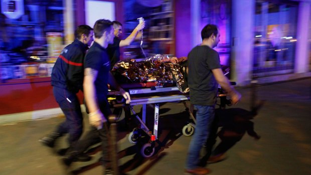 A person is being evacuated after a shooting, outside the Bataclan theater in Paris, in which 130 people died.