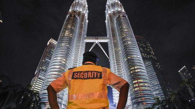 A security guard stands guard in front of Malaysia's iconic building, Petronas Twin Towers in Kuala Lumpur, Malaysia.