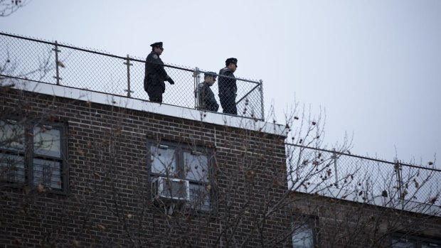 Keeping watch: Police view the scene from the rooftop of a building.