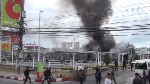 Smoke rises from an exploded vehicle outside a popular shopping centre in Pattani province, southern Thailand.