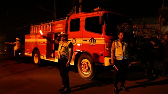 Indonesian police stand in front of a water cannon that has been positioned outside Kerobokan prison ahead of the transfer of Bali nine duo Myuran Sukumaran and Andrew Chan.