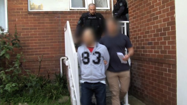 Police arrest a man during raids on drug suppliers in Sydney.