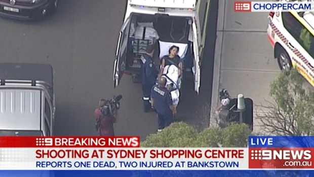 A victim is loaded into an ambulance after a shooting at Bankstown Central Shopping Centre.