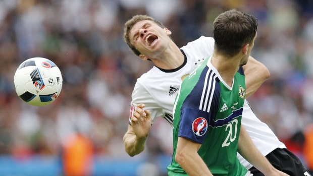Germany's Thomas Mueller, left, is challenged by Northern Ireland's Craig Cathcart.