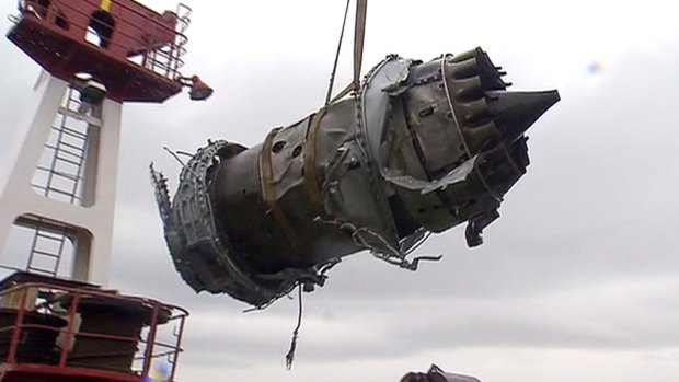 A plane engine recovered from waters outside of Sochi is lifted onto a ship. 