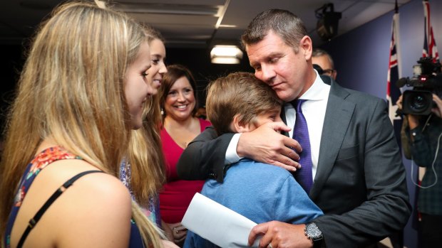 Premier Mike Baird embraces his family after a press conference announcing his resignation in Sydney. 