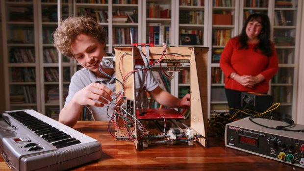 Gerardine Hansen with her son Hansen and the 3D printer he built. 