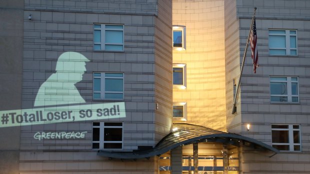 A Greenpeace banner showing US President Donald Trump and the slogan '#TotalLoser, so sad!' is projected on the facade of the US Embassy in Berlin, Germany.