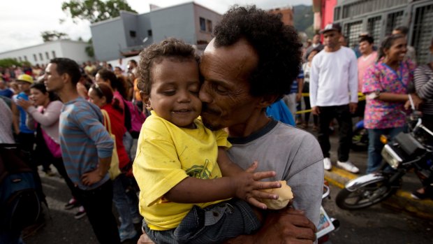 A man kisses his baby during a protest for food in Caracas, Venezuela. 