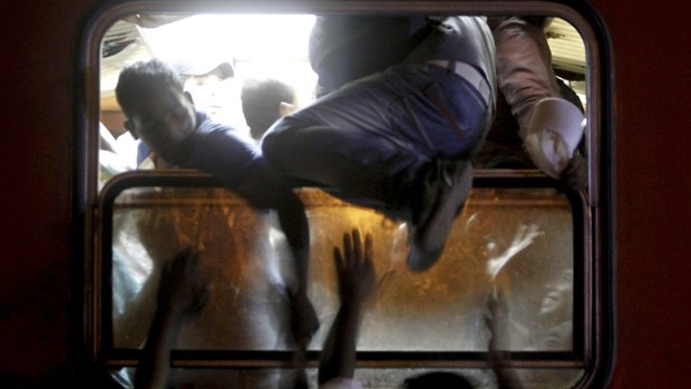 Migrants try to board a train that would take them towards Serbia at the railway station in the southern Macedonian town of Gevgelija.