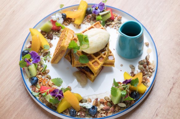 Spiced pumpkin waffle encircled by fruit, nuts and seeds.