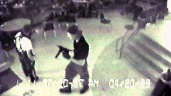 Eric Harris, left, and Dlyan Klebold, carrying a TEC-9 semi-automatic pistol, are pictured in the cafeteria at Columbine High School, in Littleton, Colorado, during their shooting rampage in 1999.