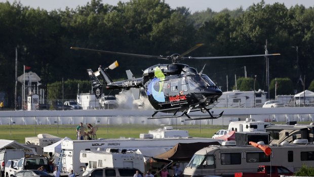 A helicopter lifts off at Pocono Raceway carrying race car driver Justin Wilson.