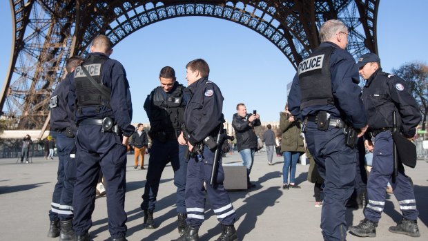 French police officers stand guard at the Eiffel Tower in Paris, France. 