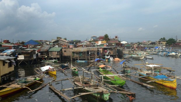 Fishing outrigger boats anchored at the mouth of a river feeding Manila Bay on Sunday after the Philippine coast guard banned sailing due to Typhoon Noul.