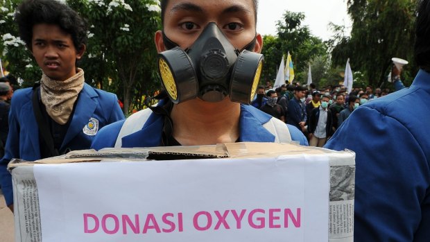 Indonesian students in Surabaya collect donations for victims of smog pollution during a protest to condemn the performance of President Jokowi's government after its first year in power.