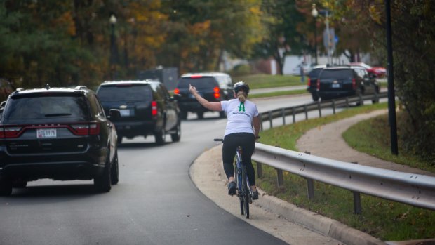 Juli Briskman gestures at President Donald Trump's motorcade in Sterling, Virginia on October 28, 2017.