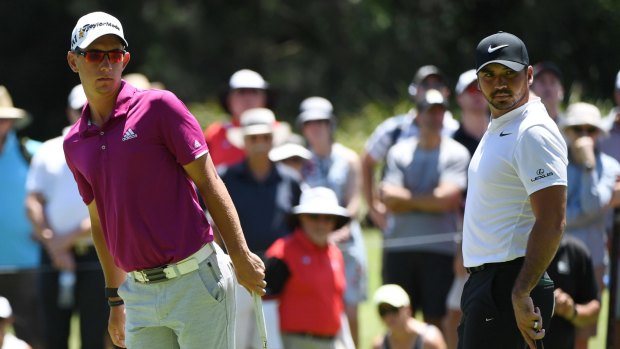 Down the leaderboard: Lucas Herbert misses a birdie putt as playing partner Jason Day watches on. The pair failed to play out an expected David and Goliath battle for honours.