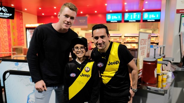Big fans: Richmond supporters Ryan Scalzo, 13, centre, and his father, Armando, had their photo taken with AFL Richmond player Jacob Townsend, left, at the VFL grand final at Etihad Stadium on Sunday. 