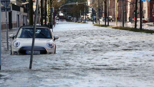 A car stands in a flooded street near the harbour in Hamburg.