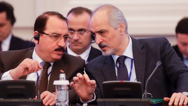 Bashar Jaafari, Syrian Ambassador to the UN and head of the Syrian delegation, right, speaks to a member of Syrian delegation during the talks on Syrian peace in Astana. 